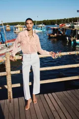 Sandalia tipo mule color beige con tira de vinilo transparente y tacón fino.