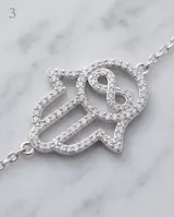 Pulsera de plata 925 con dije de mano de Hamsa decorado con circonias brillantes y un símbolo de infinito en el centro.