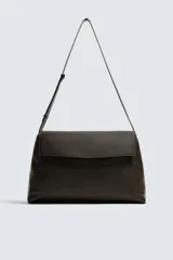 Bolso tipo bandolera de gran tamaño fabricado en piel con acabado grabado. Cuenta con un compartimento principal con cierre de solapa magnética y cremallera, además de bolsillos interiores. Incluye un asa de hombro ajustable en piel.