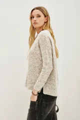 Sweater de punto con diseño calado geométrico, cuello redondo y mangas largas. Confeccionado en una mezcla de lana y alpaca, presenta una textura suave y ligera.