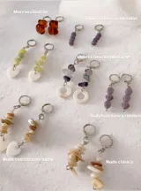Par de aros colgantes con argollas tipo huggie de metal plateado. El diseño presenta una tira de piedras naturales irregulares en tonos verdes o crudos, finalizando en un dije de corazón de nácar o piedra clara.