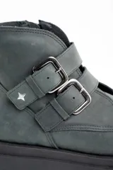 Bota corta de cuero lavado en tono gris oscuro, con suela track robusta y dos correas con hebillas metálicas en el lateral. Presenta un detalle de estrella metálica pequeña en la correa superior.