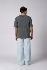 Remera de algodón gris con efecto acid wash, corte regular, mangas cortas y cuello redondo. Cuenta con un pequeño bordado tono sobre tono en el pecho y una etiqueta lateral distintiva de la marca en el ruedo.