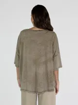 Remera color amarillo con cuello redondo y mangas cortas anchas con detalle de botones en los laterales. Diseño holgado con efecto gastado.