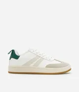 Championes de estilo casual, color blanco, con detalles en beige claro en los laterales y puntera de gamuza color gris claro. Posee suela de goma color caramelo y tirador trasero en color verde oscuro.