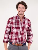 Camisa de hombre de manga larga, corte regular fit, cuello button down y cierre con botones. Diseño a cuadros tartán en tonos rojo y blanco.