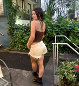 Short de jean color blanco off-white, de tiro medio, con bolsillos clásicos y terminación desmechada con flecos en el ruedo.