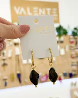 Par de aros colgantes con argolla dorada de acero y dije de piedra facetada color marrón oscuro.