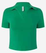 Blusa de cuello polo y manga corta, confeccionada en tejido rib de algodón con elastano. Presenta un diseño ajustado al cuerpo con escote en V y textura acanalada.