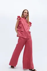 Chaleco celeste de lino con cuello mao, cierre frontal con botones y volados en hombros y bolsillos.