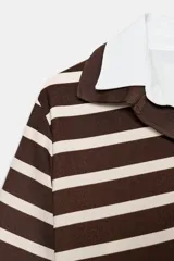 Top de estilo polo con mangas cortas, confeccionado en tejido de punto con diseño de rayas horizontales en tonos marrón y crema. Presenta cuello clásico y puños en contraste de color blanco en popelín, con cierre frontal de un botón y aberturas laterales en el bajo.