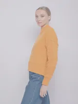 Sweater color crema de tejido de punto con cuello alto y mangas largas.