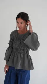 Camisa gris con frunces en el pecho, mangas largas acampanadas y corte peplum.