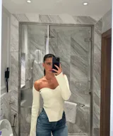 Top de tejido canalé elástico con escote cuadrado estructurado y mangas largas con puño acampanado. Presenta un diseño ajustado al cuerpo con un corte en el bajo que realza la silueta.