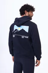 Buzo con capucha y bolsillo canguro, confeccionado en felpa azul marino. Presenta un estampado gráfico en la espalda que ilustra montañas con un sol y el texto 'Sunday Day, Our Leisure Day'.