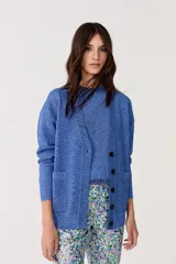 Cardigan azul con lurex, escote en V, manga larga, botones de pasta, terminaciones de rib y bolsillos delanteros.