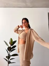 Camisa tejida color beige, de manga larga y corte holgado.