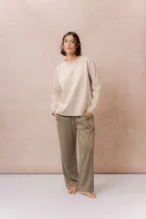 Buzo de calce relajado color beige, con cuello redondo, manga larga y recortes curvos decorativos con costuras a la vista en el frente. Terminaciones en puños y cintura.