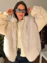 Campera puffer oversize color beige, con paneles frontales y traseros de pelo sintético suave. Presenta mangas acolchadas, cierre frontal y diseño abrigado.