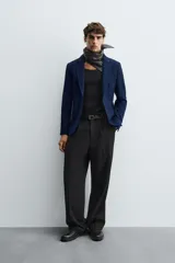 Blazer azul marino de corte recto, confeccionada en tejido con viscosa. Tiene cuello con solapas de muesca, manga larga con puño abotonado, bolsillo de vivo en el pecho y bolsillos de parche en la cadera. El bajo tiene aberturas en la espalda y el cierre es con botonadura frontal.