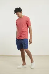 Remera gris con bolsillo ojal en el pecho, de manga corta y cuello redondo.