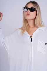 Camisa negra de corte oversize y estilo casual, confeccionada en tela liviana, con mangas largas, cuello camisero y cierre frontal con botones.