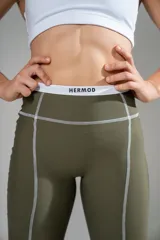 Calza deportiva de tiro alto en color verde oliva, con costuras reforzadas en contraste y cintura elástica con logo de la marca.