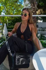 Pantalón negro de lino de corte ancho con aberturas en el ruedo y cintura con cinturón.