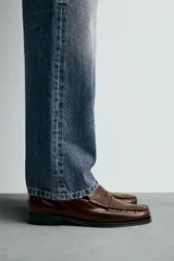 Mocasín de vestir fabricado en piel con acabado brillante, presenta detalle de antifaz en el empeine, plantilla de piel y suela a contraste con ligero tacón.