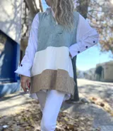 Chaleco largo tejido a rayas horizontales en color negro en la parte superior, tostado en el medio y blanco en la parte inferior.