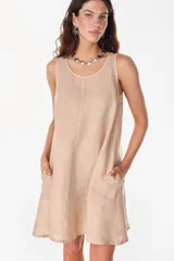 Vestido corto sin mangas color beige, de lino italiano, con escote redondo y bolsillos delanteros laterales.