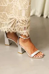 Sandalias de tacón ancho con tira delantera y correa ajustable al tobillo, confeccionadas en tela de tapicería con forro y plantilla de cuero.