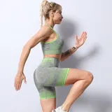 Top deportivo gris con detalles en verde neón, de breteles finos y espalda deportiva.