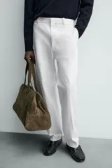 Pantalón chino de corte oversized confeccionado en tejido de algodón con estructura twill. Presenta bolsillos frontales, bolsillos traseros de vivo y cierre frontal con cremallera y gancho metálico oculto.