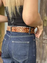 Cinturón de cuero con estampado animal print de jirafa, hebilla metálica rectangular y presilla movible.