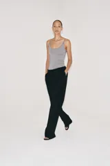 Pantalón de lana negro de tiro medio con trabillas en la cintura, bolsillos laterales ocultos y pierna ancha.