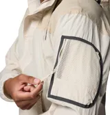 Campera Columbia modelo Challenger Windbreak Omni-Shield de color beige claro con detalles en tostado. Cuenta con capucha ajustable, media cremallera frontal, gran bolsillo canguro central con solapa y cierre de velcro, y puños elásticos.