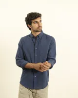 Camisa de manga larga confeccionada en una mezcla de algodón y lino, con cuello abotonado, cierre frontal de botones y un bolsillo en el pecho.