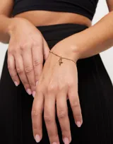 Dije charm de aleación de metales bañados en oro 18k con forma de cruz.