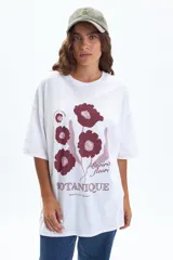 Remera oversize blanca de manga corta, con estampado frontal de flores en tonos bordó y texto "Esprit Fleuri Botanique Marseille, France".
