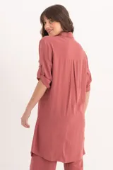 Camisa larga color rosa de lino con cuello clásico, abotonada al frente y mangas 3/4 con trabillas.