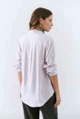 Camisa blanca de manga larga con cuello clásico, cierre de botones frontal y bolsillo de parche en el pecho.