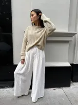 Sweater color crema tejido con diseño en ochos y cuello redondo.