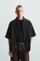 Camisa de manga corta con cuello solapa, confeccionada en tejido de mezcla de lyocell con textura de efecto arrugado y cierre frontal de botones.