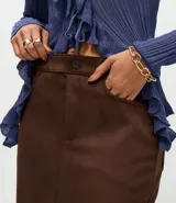 Pollera midi de gamuza sintética color bordó, con cintura alta, bolsillos laterales y tajo central delantero.