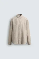 Camisa de manga larga color beige claro, confeccionada en lino, con cuello italiano y cierre frontal de botonadura.