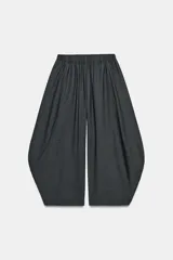 Pantalón de tiro medio con cintura elástica y diseño de pierna con volumen, confeccionado en tejido gris oscuro.