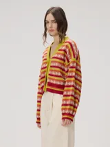 Cardigan crop de punto de algodón con mangas semi-abultadas, hombros caídos y puños acanalados. Presenta un diseño de rayas horizontales multicolor con gráficos en miniatura y cierre frontal de botones.