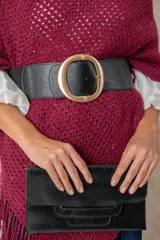 Cinturón ancho tipo faja, confeccionado con una banda elástica negra y paneles de cuero italiano en la parte frontal. Presenta una hebilla metálica circular de gran tamaño con acabado dorado brillante.