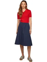 Falda midi azul marino de corte evasé, con botones frontales a lo largo de toda la prenda y logo de la marca bordado en el ruedo.